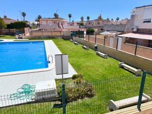 a fence with a swimming pool on top of a building at Cozy Bungalow with Private Terrace and Communal Pool in Torrevieja in Torrevieja