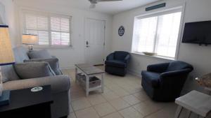 un soggiorno con divano, sedie e TV di Broadway Beach Unit 1 a Cape May