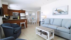 un soggiorno con un divano blu e una cucina di Broadway Beach Unit 1 a Cape May