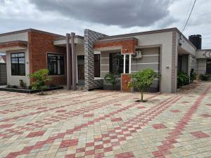 a house with a brick driveway in front of it at King Cave Luxury Apartment in Nkunjila
