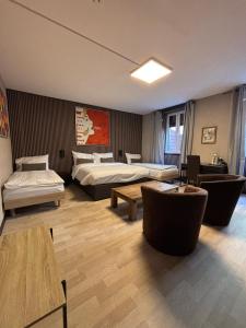 um quarto de hotel com duas camas e mesas e cadeiras em Hotel Parc & Lac em Montreux