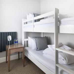 a bedroom with a bunk bed and a table at Harbour Hotel & Spa St Ives in St Ives
