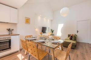 una cucina e una sala da pranzo con tavolo e sedie di Appartement 3 chambres en centre ville et proche métro a Croix