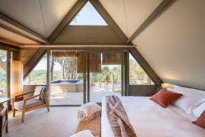 una camera da letto con un letto e una grande finestra di Boutique Hotel Poggio ai Santi - Adults Only a San Vincenzo