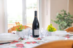 a bottle of wine sitting on a table with glasses at Piombino Apartments Casa Regina in Piombino