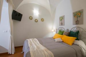 a bedroom with a bed with yellow and green pillows at Capo Rama Suites & Rooms in Terrasini +46 photos