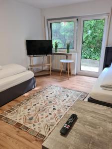 a living room with two beds and a remote control at WellandHome Aalen - Business Apartment - 4 single beds in Aalen