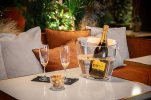 a bottle of champagne sitting on a table with two glasses at Hôtel L'Adresse in Saint Malo