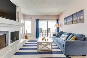 a living room with a blue couch and a fireplace at Beachfront New Smyrna Condo: 1 Mi to Flagler Ave in New Smyrna Beach