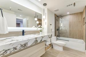 a bathroom with a sink and a toilet and a tub at Beachfront New Smyrna Condo: 1 Mi to Flagler Ave in New Smyrna Beach +21 photos
