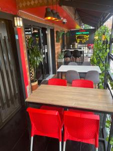 a table and red chairs in front of a restaurant at Hotel San Pablo boutique H9 in Medellín