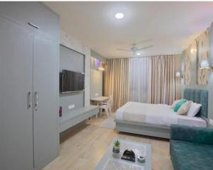 ジャイプールにあるUpasana Luxurious Apartmentのベッドとソファとテーブルのある寝室