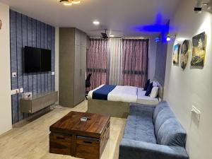 ジャイプールにあるUpasana Luxurious Apartmentのソファとベッドのあるリビングルーム