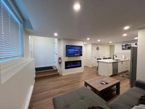 sala de estar amplia con sofá y cocina en Cozy 2 bedrooms Suite Near Calgary Airport Sleeps 6, en Calgary