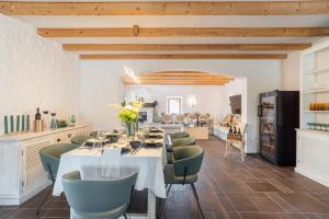 a dining room with a white table and green chairs at Aurora Lukorana in Lukoran