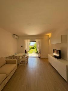 a living room with a couch and a television and a table at Porto San Paolo Mono apartment in Porto San Paolo
