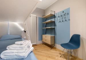 a bedroom with a blue bed and a blue chair at Palazzo Righi - App Blu in Carisolo