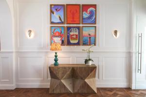 a room with a table and paintings on the wall at Harbour Hotel & Spa St Ives in St Ives