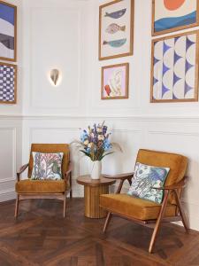 two chairs and a table with a vase of flowers at Harbour Hotel & Spa St Ives in St Ives