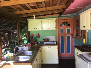 uma cozinha com armários brancos e uma pia em Cottage Rodney Bay 2 bedrooms em Gros Islet