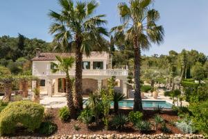 a villa with a swimming pool and palm trees at Aurora Lukorana in Lukoran