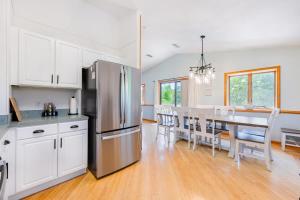een keuken en eetkamer met een roestvrijstalen koelkast bij Pool Hot Tub Beach Gear included in Corolla
