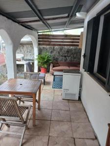a patio with a table and chairs and a couch at Villa des Filaos et du lagon o6, 93 , 70 , 59 , 79 in Saint-Leu