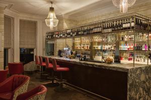 a bar with red chairs and a counter with alcohol at Harbour Hotel & Spa St Ives in St Ives
