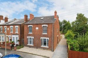 an old red brick house with a driveway at Spacious House Private Parking & Garden in Gloucestershire