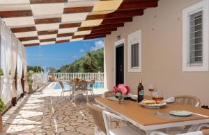patio ze stołem i krzesłami z widokiem w obiekcie Villa Dream Apartments w mieście Vasiliki