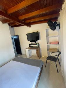 a bedroom with a bed and a tv and a chair at Hotel boutique San Pablo H10 in Medellín