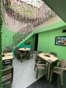 a restaurant with tables and chairs and a ceiling with flowers at Hotel boutique San Pablo H10 in Medellín