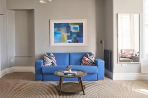 a blue couch in a living room with a table at Harbour Hotel & Spa St Ives in St Ives
