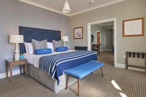 a bedroom with a large bed with a blue comforter at Harbour Hotel & Spa St Ives in St Ives