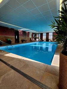 a large blue swimming pool in a building at Résidence Domitys Pèira Ròsa - Toulouse Purpan in Toulouse