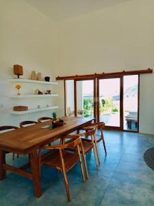 a dining room with a wooden table and chairs at Villa Aura Lombok in Selong Belanak