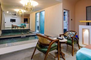 a room with a pool and two chairs and a table at Eraaya Farms Luxury Pet Friendly Villa with Pool in Dabok +7 photos