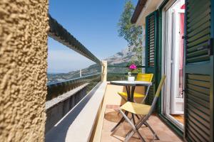 a patio with a table and chairs on a balcony at Villa Lora in Tučepi