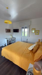 a large yellow bed in a room with a table at B&B Il Balcone Fiorito in Imola +33 photos