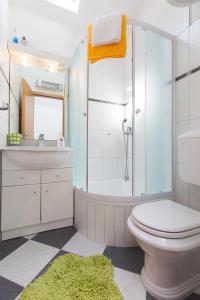 a bathroom with a toilet and a sink and a shower at Villa Lora in Tučepi