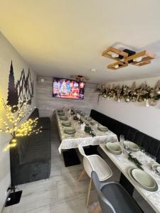a dining room with a long table and a tv at Casa Germana Straja in Straja
