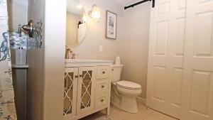 Un baño blanco con inodoro y lavabo. en Sunswept - Pet Friendly!, en North Cape May 11 fotos más