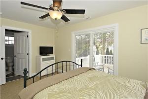 una camera da letto con un letto e un ventilatore a soffitto di Congress Cottage a Cape May