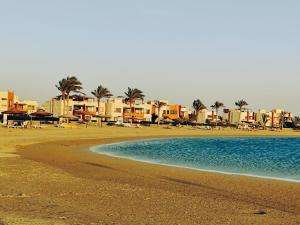 拉斯苏德尔فيلا هولداي فانتازيا Sea VIEW的拥有多座酒店和棕榈树的海滩