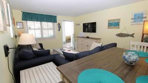 sala de estar con mesa y sofás azules en Broadway Beach Unit 3, en Cape May