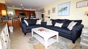 Una sala de estar con un sofá azul y una mesa. en Broadway Beach Unit 3, en Cape May