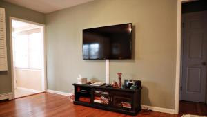 un salon avec une télévision à écran plat au mur dans l'établissement 103 Broadway, à Cape May