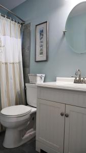 une salle de bain avec toilettes, lavabo et miroir dans l'établissement 103 Broadway, à Cape May