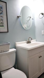 une salle de bain avec des toilettes blanches et un miroir dans l'établissement 103 Broadway, à Cape May 12 autres photos