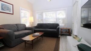 a living room with a couch and a table at Cottage On Cambridge in Cape May Point